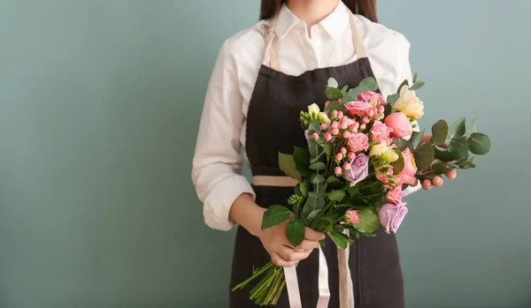 Kvinnliga florist med vacker bukett på färgbakgrund — Stockfoto