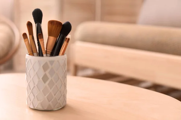 Holder with makeup brushes on table — Stock Photo, Image