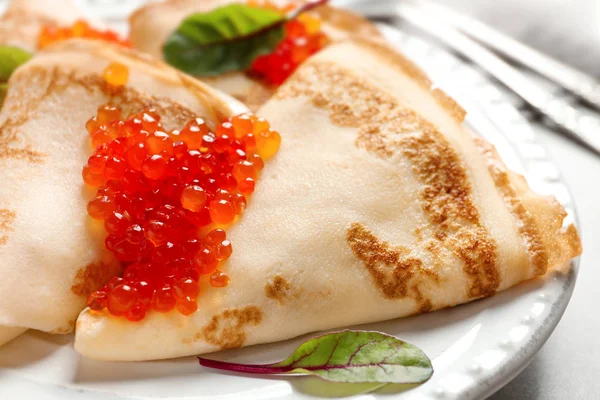 Thin pancakes served with red caviar on plate, closeup — Stock Photo, Image