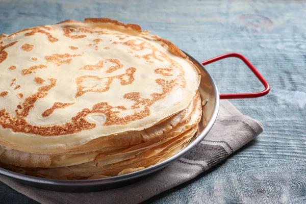 Plat avec de fines crêpes sur table en bois — Photo