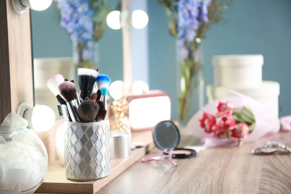 Soporte con cepillos de maquillaje profesional en mesa de madera — Foto de Stock