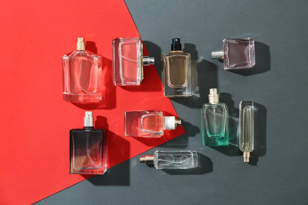 Parfümflaschen auf buntem Hintergrund, flach gelegt — Stockfoto
