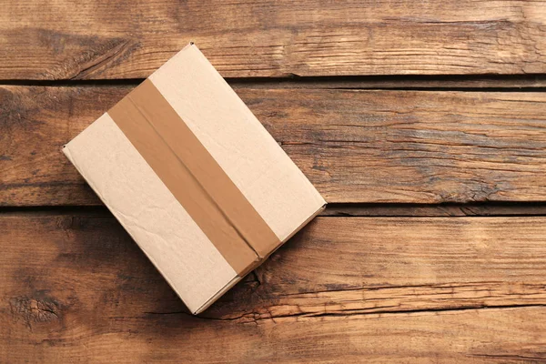 Cardboard box on wooden background — Stock Photo, Image