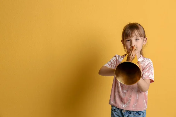 Cute little girl with megaphone on color background — Stock Photo, Image