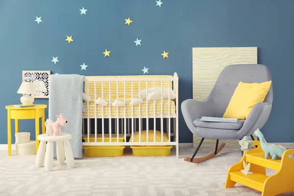 婴儿房室内配有婴儿床和墙壁附近的摇椅 — 图库照片
