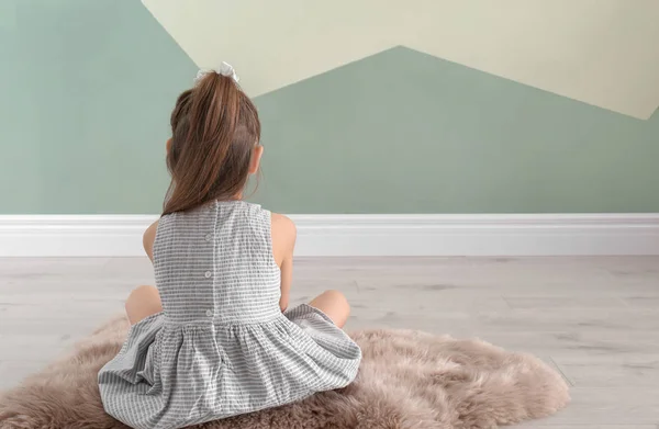 Одинокая маленькая девочка сидит на полу в помещении. Детский аутизм — стоковое фото