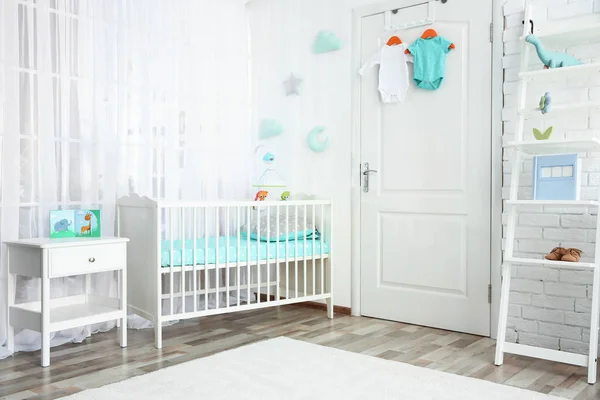 Modern interior of light cozy baby room with crib — Stock Photo, Image