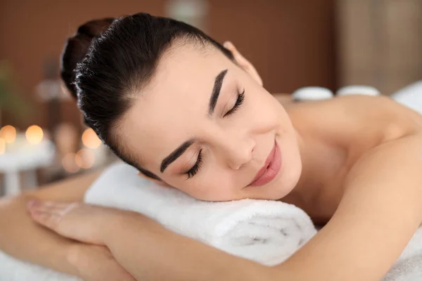 Young woman undergoing hot stone therapy in spa salon — Stock Photo, Image