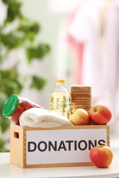 Caja de donaciones con productos alimenticios en la mesa en interiores — Foto de Stock