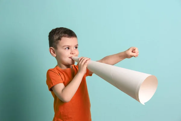 Menino adorável com megafone de papel no fundo de cor — Fotografia de Stock