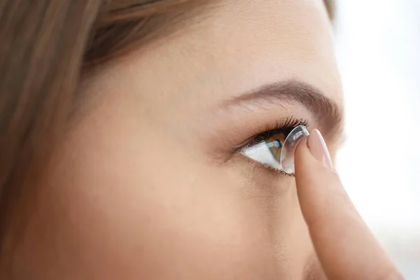 Mujer joven poniendo lentes de contacto en su ojo, primer plano —  Fotos de Stock