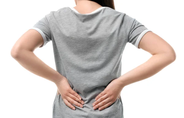 Young woman suffering from back pain on white background — Stock Photo, Image