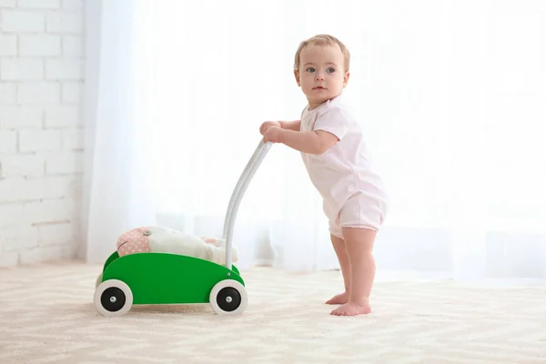 Lindo bebé con andador de juguete en el interior — Foto de Stock