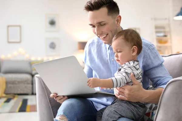 Jonge vader met zijn schattige zoontje met behulp van laptop thuis — Stockfoto