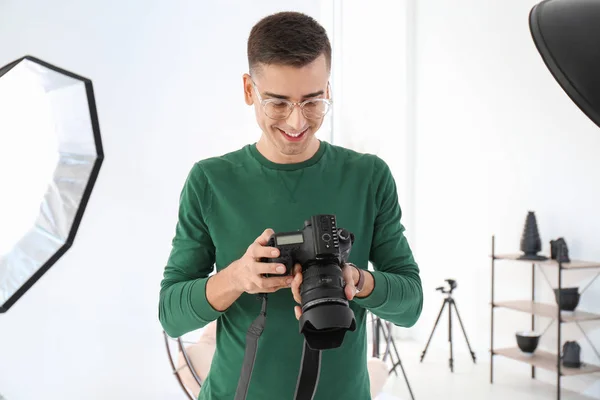 Jovem fotógrafo trabalhando em estúdio profissional — Fotografia de Stock