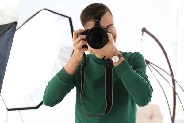 Joven fotógrafo trabajando en estudio profesional — Foto de Stock