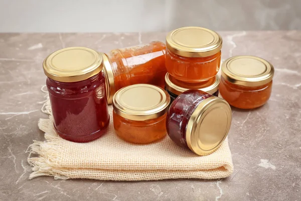 Potten met verschillende zoete jam op tafel — Stockfoto