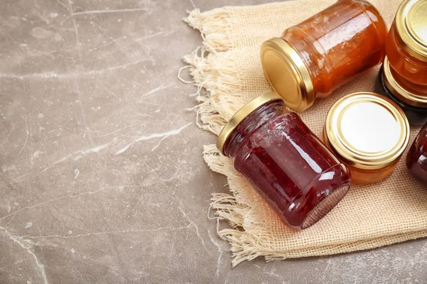 Jars with different sweet jam on table — Stock Photo, Image