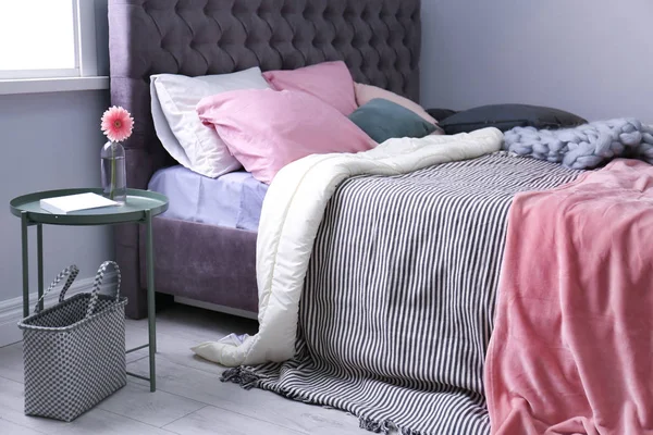 Bequemes Bett im hellen, modernen Zimmer — Stockfoto