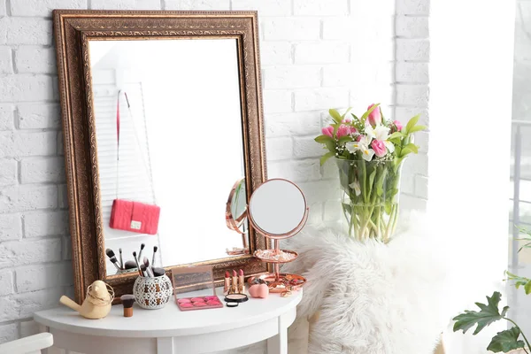 Mesa con hermoso espejo y cosméticos en la sala de maquillaje moderno —  Fotos de Stock
