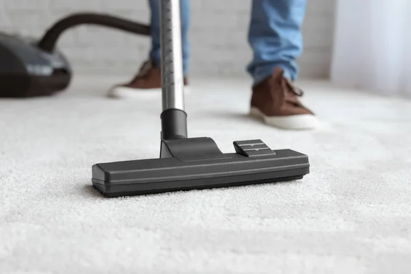 Man cleaning carpet with vacuum at home — Stock Photo, Image