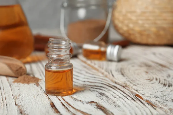 Крупним планом пляшка з олією кориці на дерев'яному столі — стокове фото