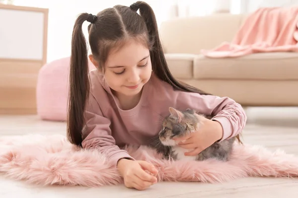 Linda niña con gato acostado en el suelo en casa —  Fotos de Stock