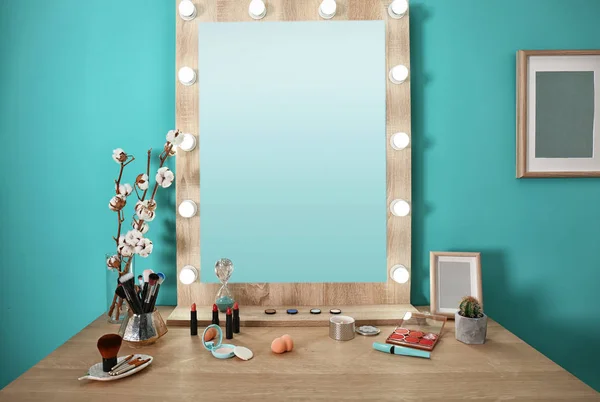 Декоративная косметика и инструменты на туалетном столике возле зеркала в гримерной — стоковое фото