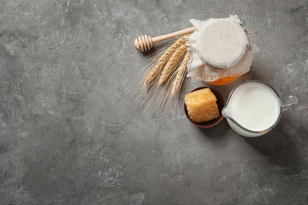 Hermosa composición con leche y miel sobre fondo gris — Foto de Stock