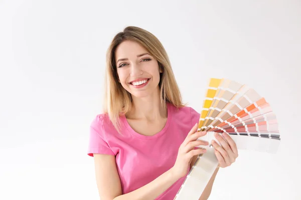 Young woman with color palette on white background — Stock Photo, Image