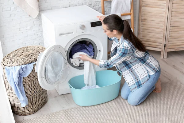 Young woman doing laundry at home — Stock Photo, Image