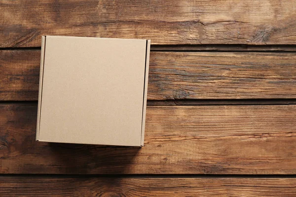 Картонная коробка на деревянном фоне — стоковое фото