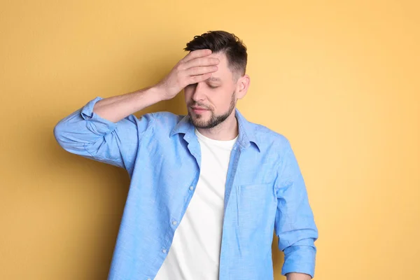 Člověk trpící bolesti hlavy na barvu pozadí — Stock fotografie
