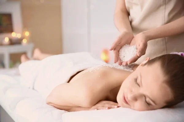 Mulher bonita fazendo massagem com esfoliação corporal no salão de spa — Fotografia de Stock