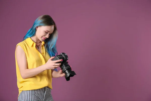 Jovem fotógrafa com câmera no fundo de cor — Fotografia de Stock