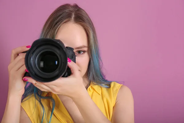 Giovane fotografo femminile con fotocamera su sfondo a colori — Foto Stock