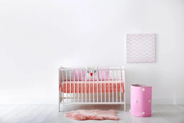 Baby room interior with crib near wall — Stock Photo, Image