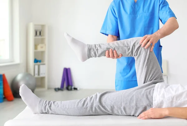 Fysiotherapeut werkt met mannelijke patiënt in kliniek — Stockfoto