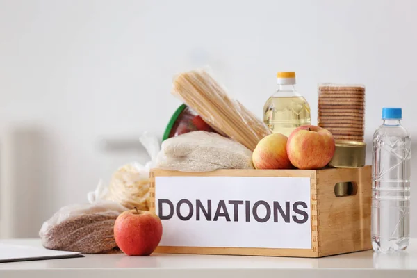 Caja de donaciones con productos alimenticios en la mesa en interiores — Foto de Stock