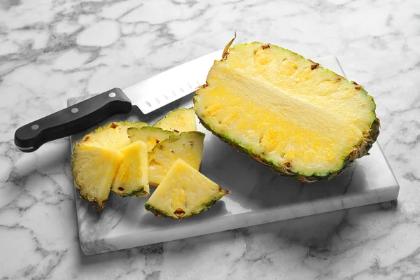 新鮮なスライスしたパイナップルと大理石のテーブルの上のナイフでボード — ストック写真
