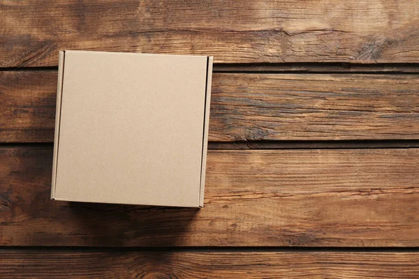 Cardboard box on wooden background Stock Image