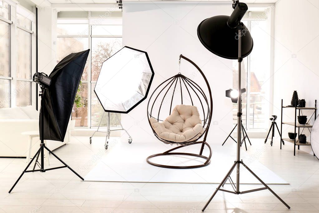 Hanging chair in photo studio with professional equipment