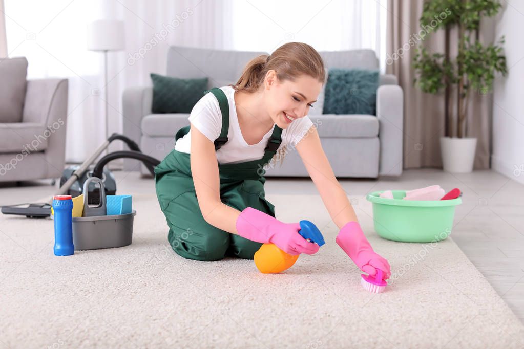 Female worker cleaning carpet at home