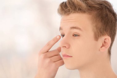 Genç çocuk onun gözünde Kontakt lens koyarak arka plan bulanık