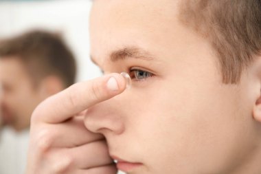 Genç çocuk gözü kapalı Kontakt lens koyarak