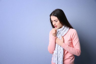 Genç kadın renk arka plan üzerinde öksürük