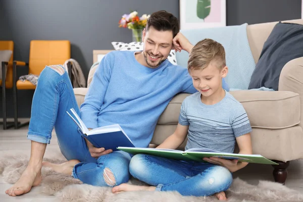 Liten pojke och hans pappa som läser böcker hemma — Stockfoto