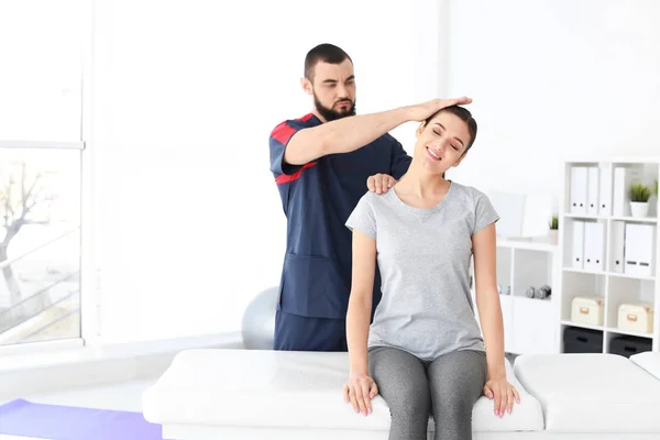 Physiotherapist working with young female patient in clinic — Stock Photo, Image