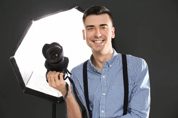 Jeune photographe avec caméra professionnelle en studio — Photo