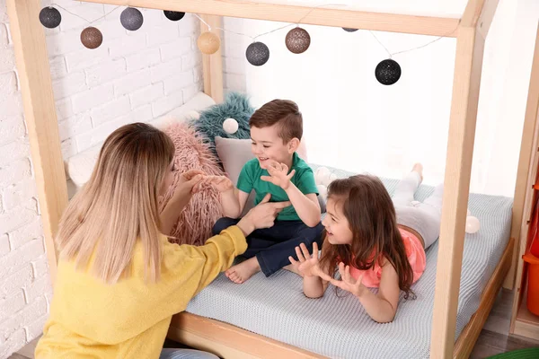 Niñera y niños pequeños jugando en casa —  Fotos de Stock